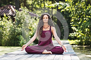 A woman leading a healthy lifestyle and practicing yoga, meditates with her eyes closed