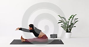 A woman leading a healthy lifestyle and practicing yoga, performs an exercise to stretch the muscles of the back and legs