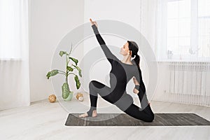 Woman leading a healthy lifestyle and practicing yoga, performs a variation of the anjaneyasana exercise with virasana