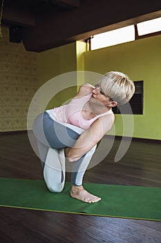 A woman leading a healthy lifestyle and practicing yoga performs a vatajanasana exercise, horse pose, trains on a mat