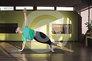 A woman leading a healthy lifestyle and practicing yoga, performs the wasishthasana exercise, the posture of a side plank