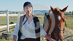 A woman is leading her horse at an outdoor manege