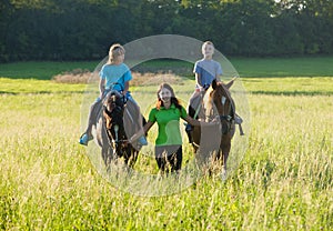 Woman Leading Two Horses with Boys