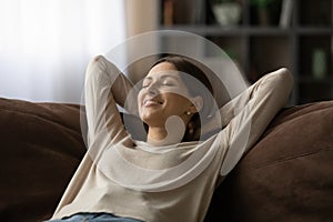 Woman lean on sofa closing eyes breath fresh conditioned air photo