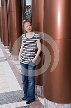 Woman leaning against a pole