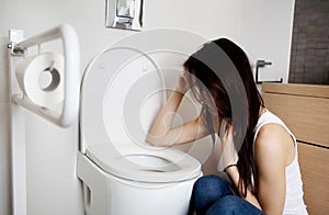 Woman leaning on open toilet seat at indoor bathroom