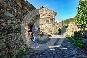 Woman leaning out of a window of an old stone house in the village of Patones de Arriba, Madrid. photo