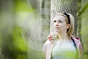 Woman leaning on tree