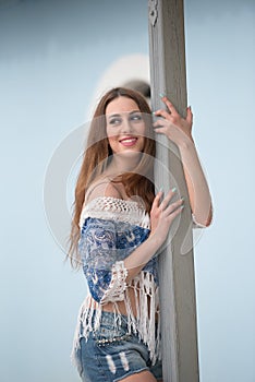 Woman leaning on wooden pillar