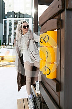 Woman Leaning on Wooden Wall With Coat Over Shoulders