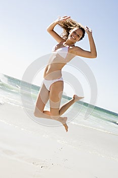 Woman leaping on beach