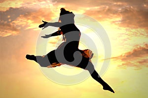 Una mujer saltando sobre el atardecer 