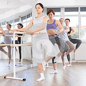 Woman learning passe retire in ballet class for beginners photo