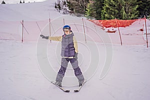 Woman learning to ski. Young woman skiing on a snowy road in the mountains