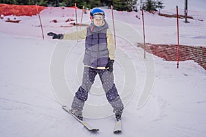 Woman learning to ski. Young woman skiing on a snowy road in the mountains