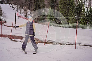 Woman learning to ski. Young woman skiing on a snowy road in the mountains