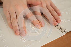 A woman learns the Braille alphabet using a decoder.