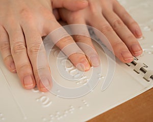 A woman learns the Braille alphabet using a decoder.