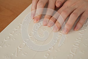 A woman learns the Braille alphabet using a decoder.