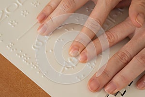 A woman learns the Braille alphabet using a decoder.