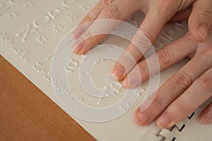 A woman learns the Braille alphabet using a decoder.