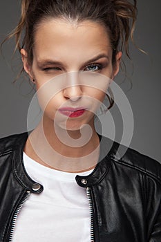 Woman in leather jacket winking and fooling around photo