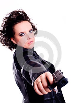 Woman in leather wear holding gun over white