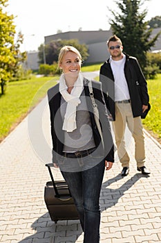 Woman leaving with baggage man walk behind