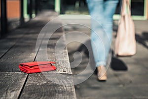 Woman is leaving from a bench where she forgot her leather wallet