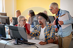 Woman lecturer in computer class assisting student