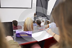 Woman lecturing students in a lecture theatre, student POV