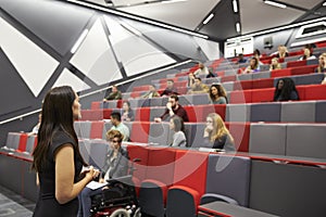 Woman lecturing students in a university lecture theatre photo