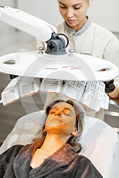 Woman during led light therapy at medical office