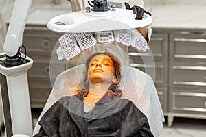 Woman during led light therapy at medical office