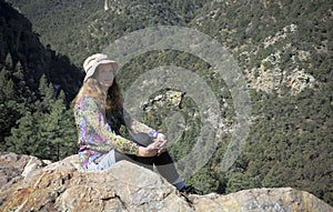 A Woman on a Ledge Overlooking a Forest