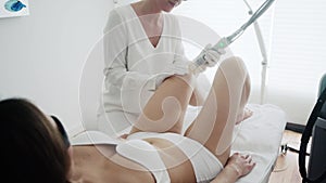 Woman in leg hair removal session at beauty parlor