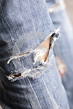 Woman leg in holed jeans