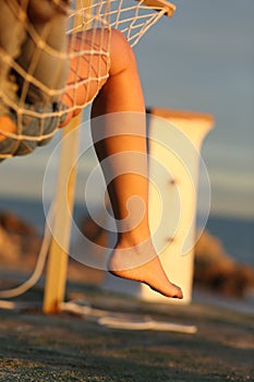 Woman leg relaxing on hammock on the beach