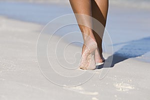 Woman leg's on white sand beach