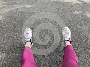 Woman leg wear pink pant and sneaker shoe on concrete road