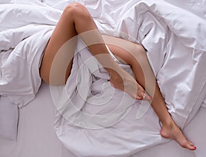 Woman legs on the bed