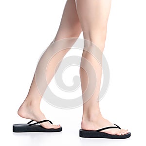 Woman legs in black flip flops goes