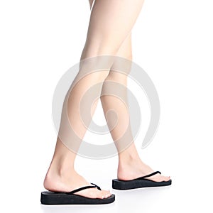 Woman legs in black flip flops goes
