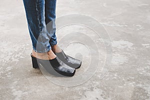 Woman legs in denim pants black stylish high heels shoes outdoo