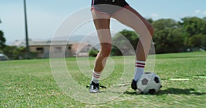 Woman, legs and feet practice in soccer on green grass field for sports training, dribbling or goal. Closeup of female