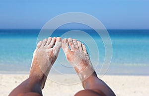 Woman legs laying on the ocean shore in the sunshine