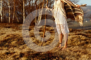 Woman legs in native indian american boho dress walking in windy