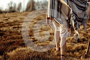 Woman legs in native indian american boho dress walking in windy