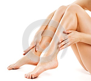 Woman Legs over White Background. Leg and Body Skin Health Care. Beauty Model depilating Hair and applying Cream