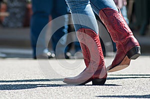 Woman legs with red american boots at country show in